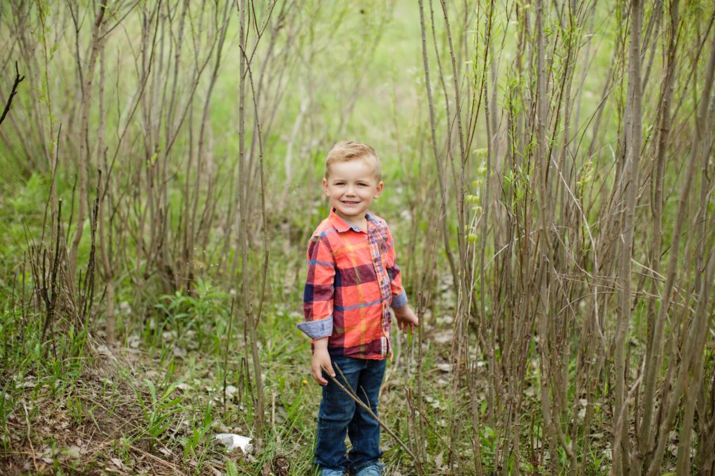 Boy in Flannel playing in the woods